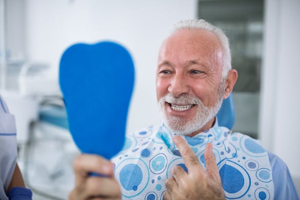 Man Looking At Teeth In Mirror